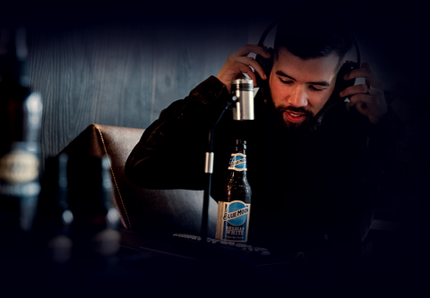 man with headphones and a beer